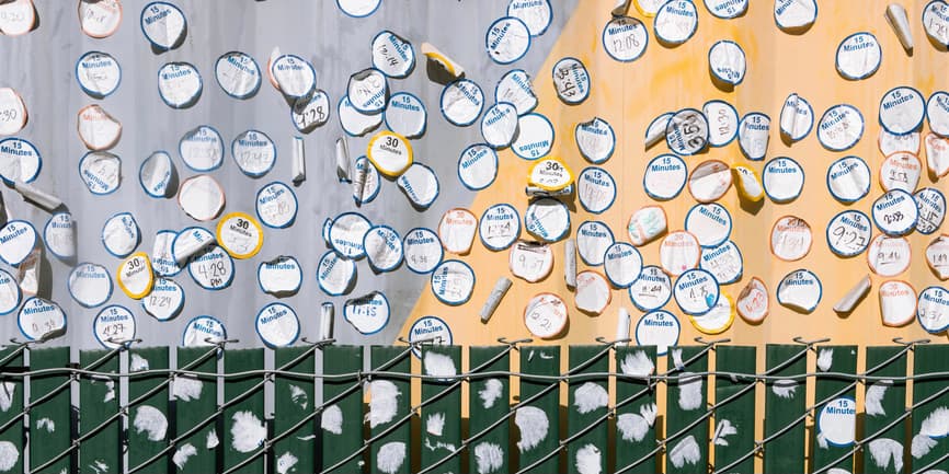 A wall of discarded vaccine wait time stickers from the early days of the Covid-19 vaccine rollout.