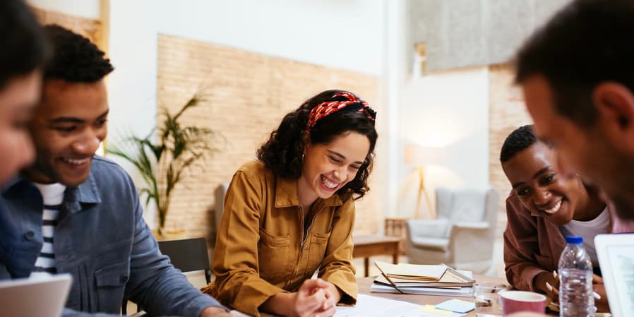 Smiling coworkers Happy casually dressed business people working together and sharing creative ideas about new project while having meeting in loft office