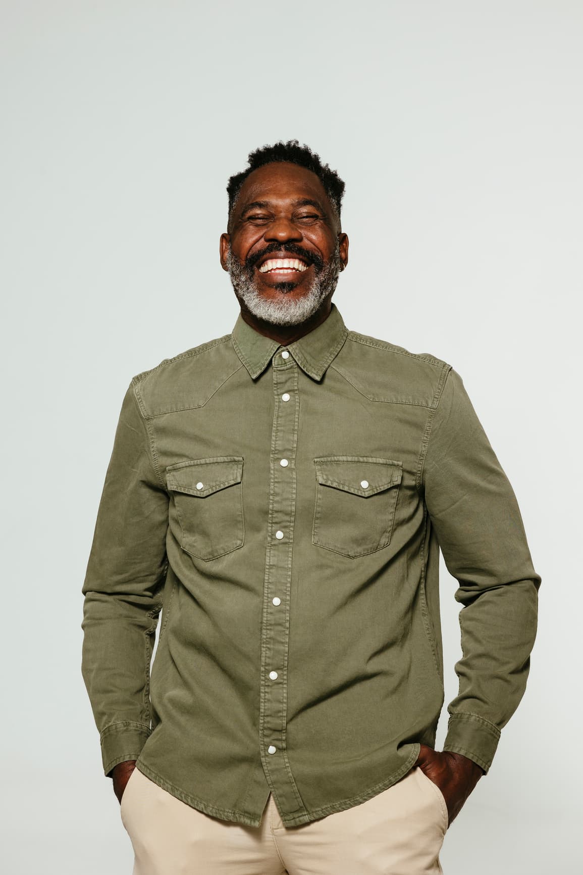 Hombre con camisa verde oliva sonriendo
