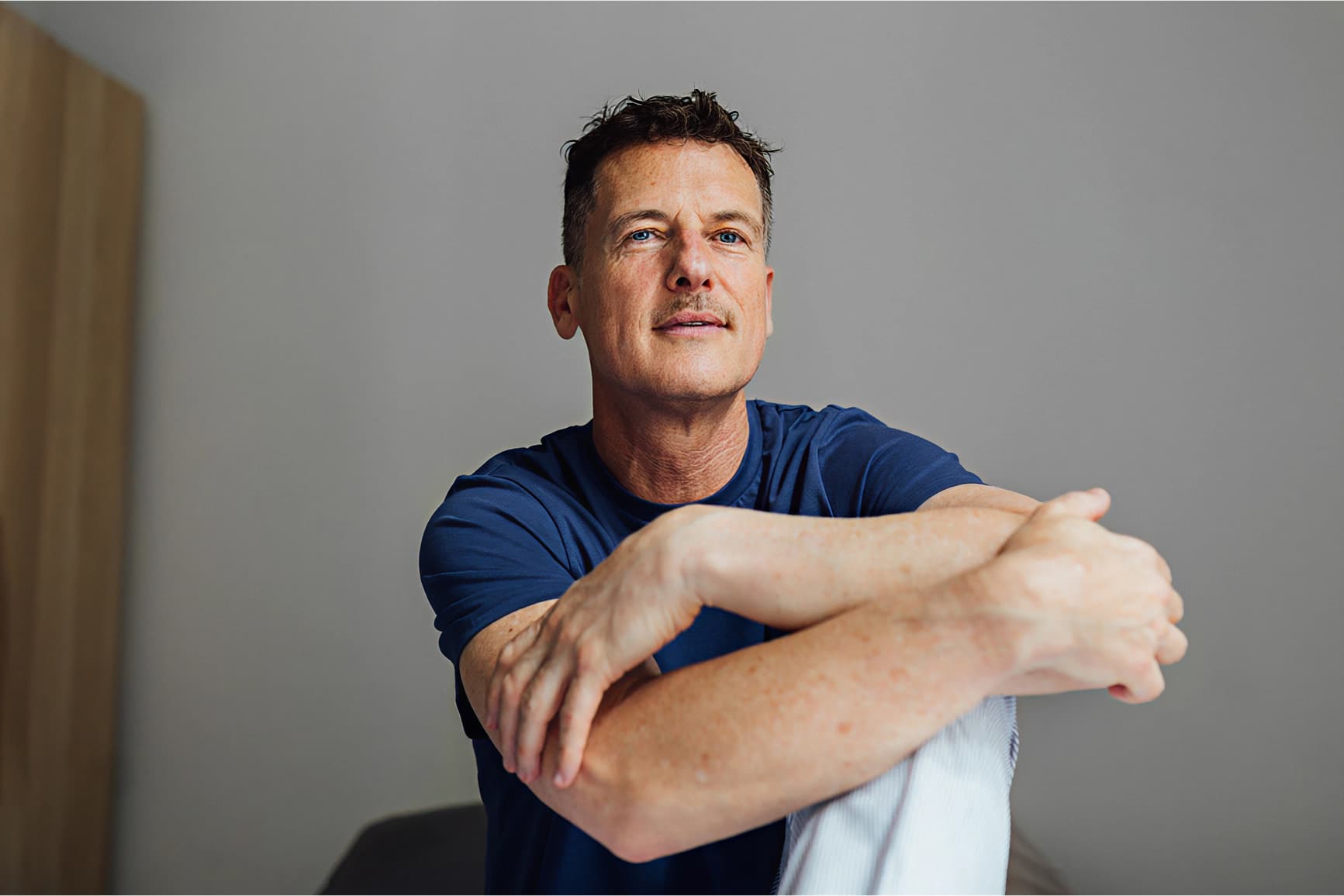 Hombre sentado con los brazos en la silla